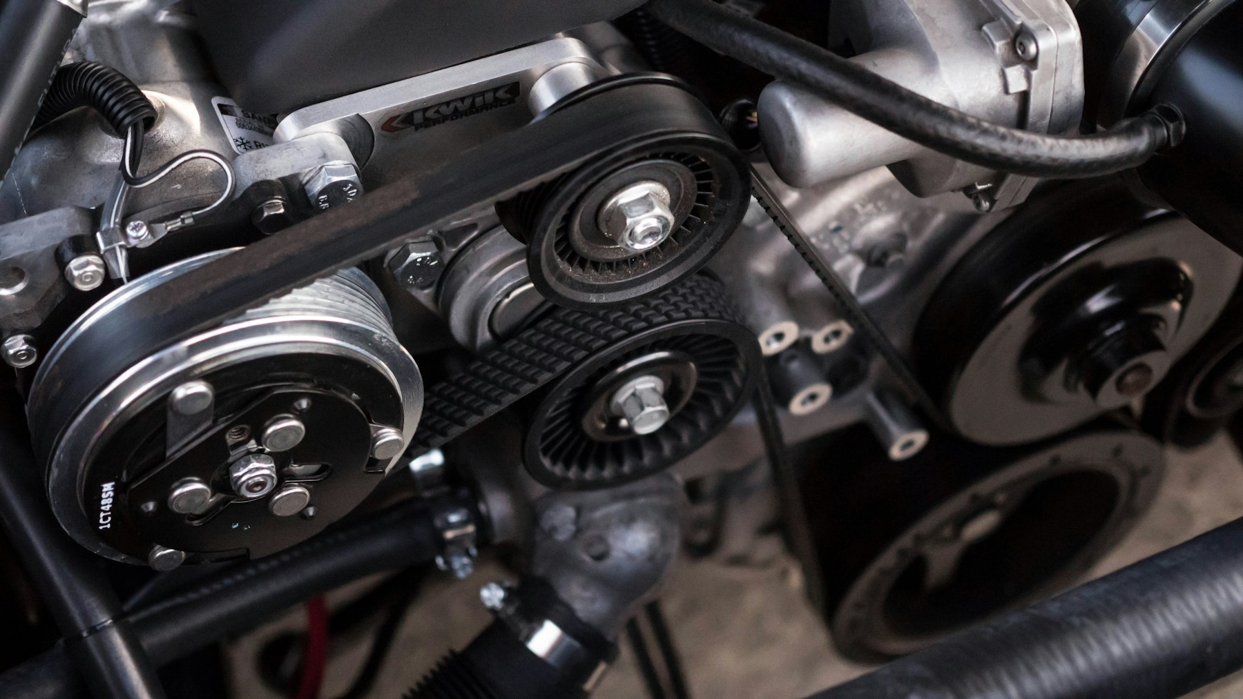 Close-up of hands working on a vehicle engine